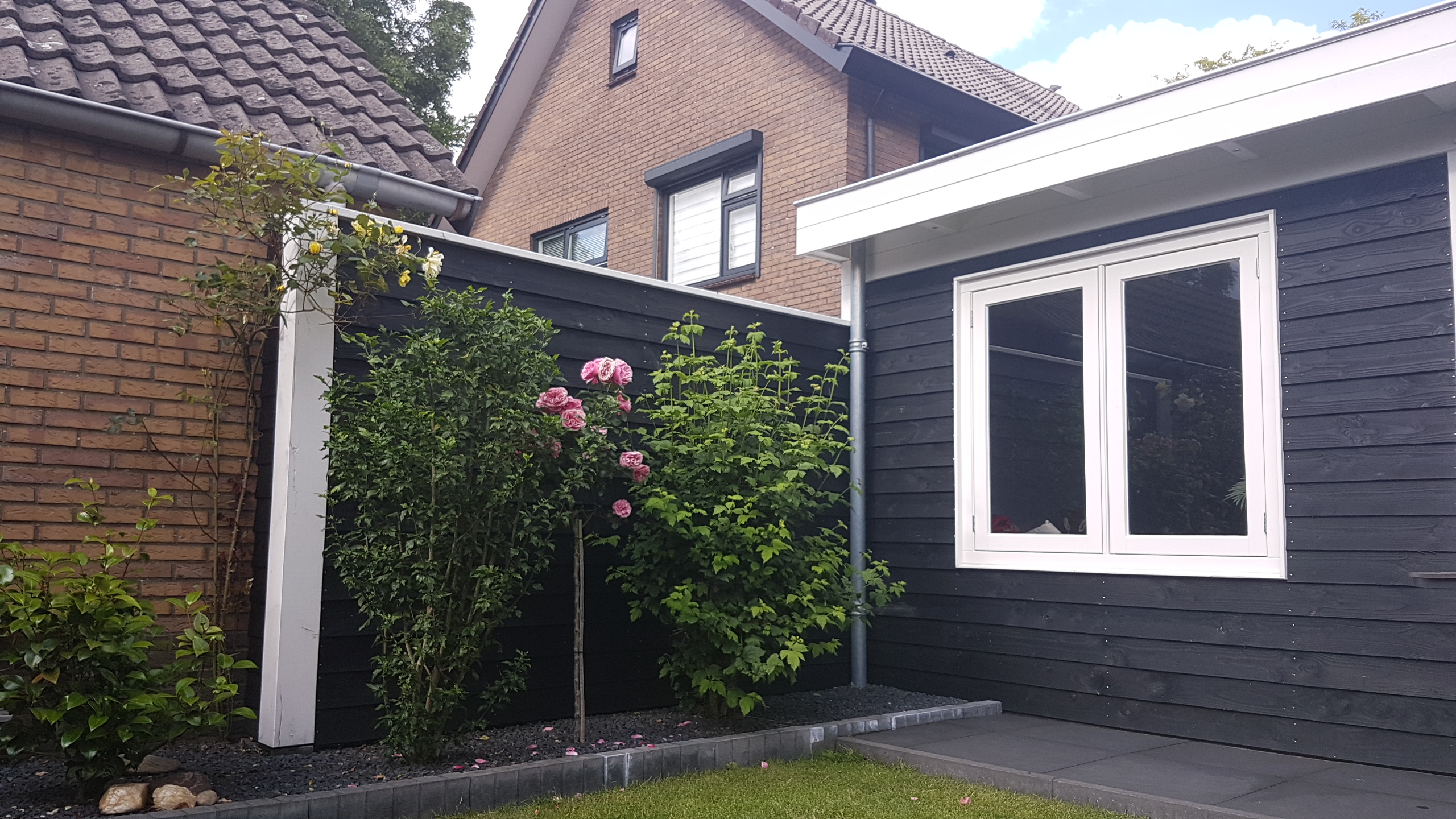 Zwarte schutting met natuurlijk groen