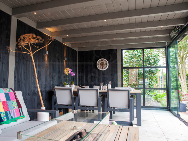 inrichting-tuinkamer-moderne-tuin-met-douglas--houten-overkapping-met-glazenschuifdeuren-schuifwanden-houten-tuinkamer-Siena-Trendhout