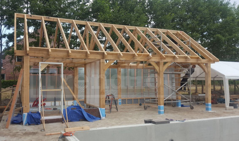montage-Trendhout-douglas-houten-schuur-met-overkapping-poolhouse-technische-ruimte-bij-zwembad-trendhout-zadeldak-laten-bouwen-eiken-hout