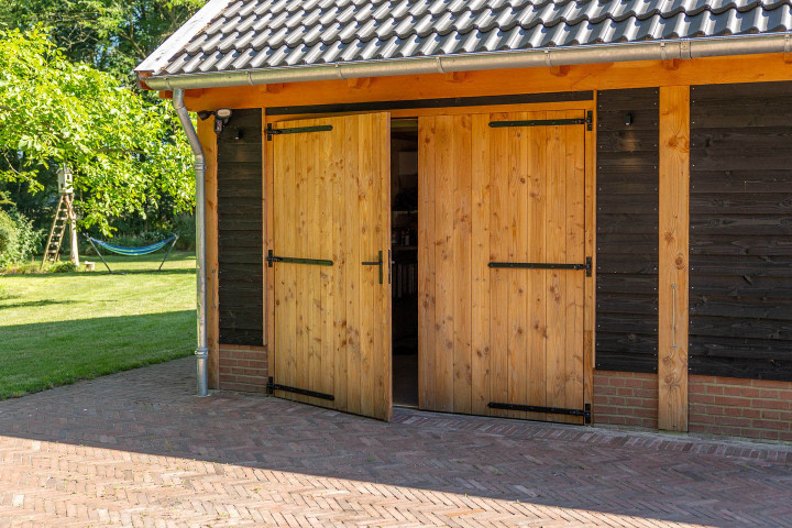 detail-van-zadeldak-xxl-met-douglas-opgeklampte-deuren-wanden-van-douglas-potdekselplanken-en-betonpannen-antraciet