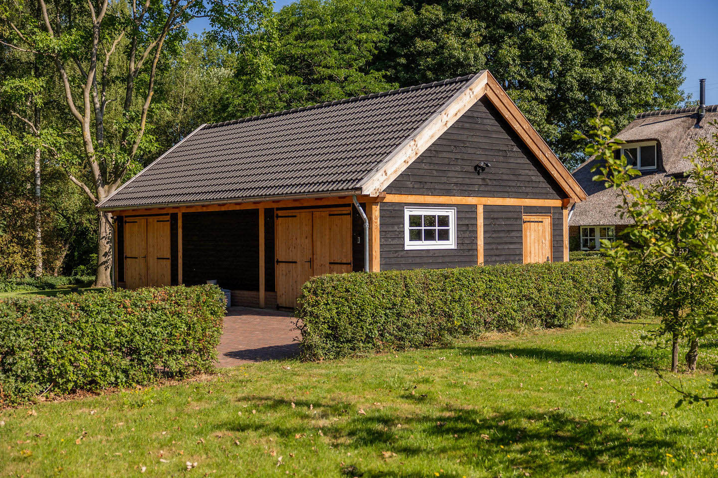 zadeldak-xxl-met-douglas-constructie-wanden-van-douglas-potdekselplanken-opgeklampte-deuren-douglas-uitzetraam-betonpannen-antraciet-wandlampen-down-zwart-en-zinken-dakgoot