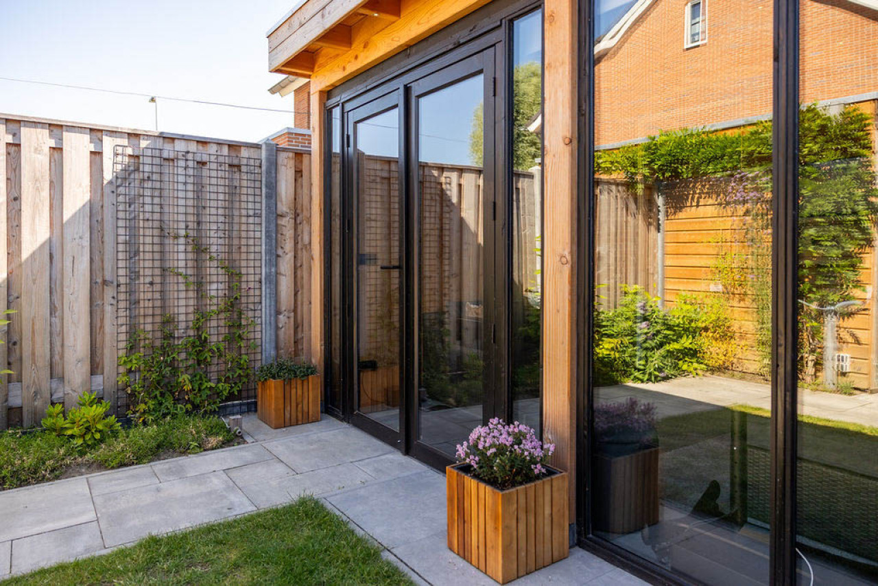 moderne-aanbouw-veranda-ancona-met-glazen-wanden-en-deuren-aan-een-woning-in-de-tuin