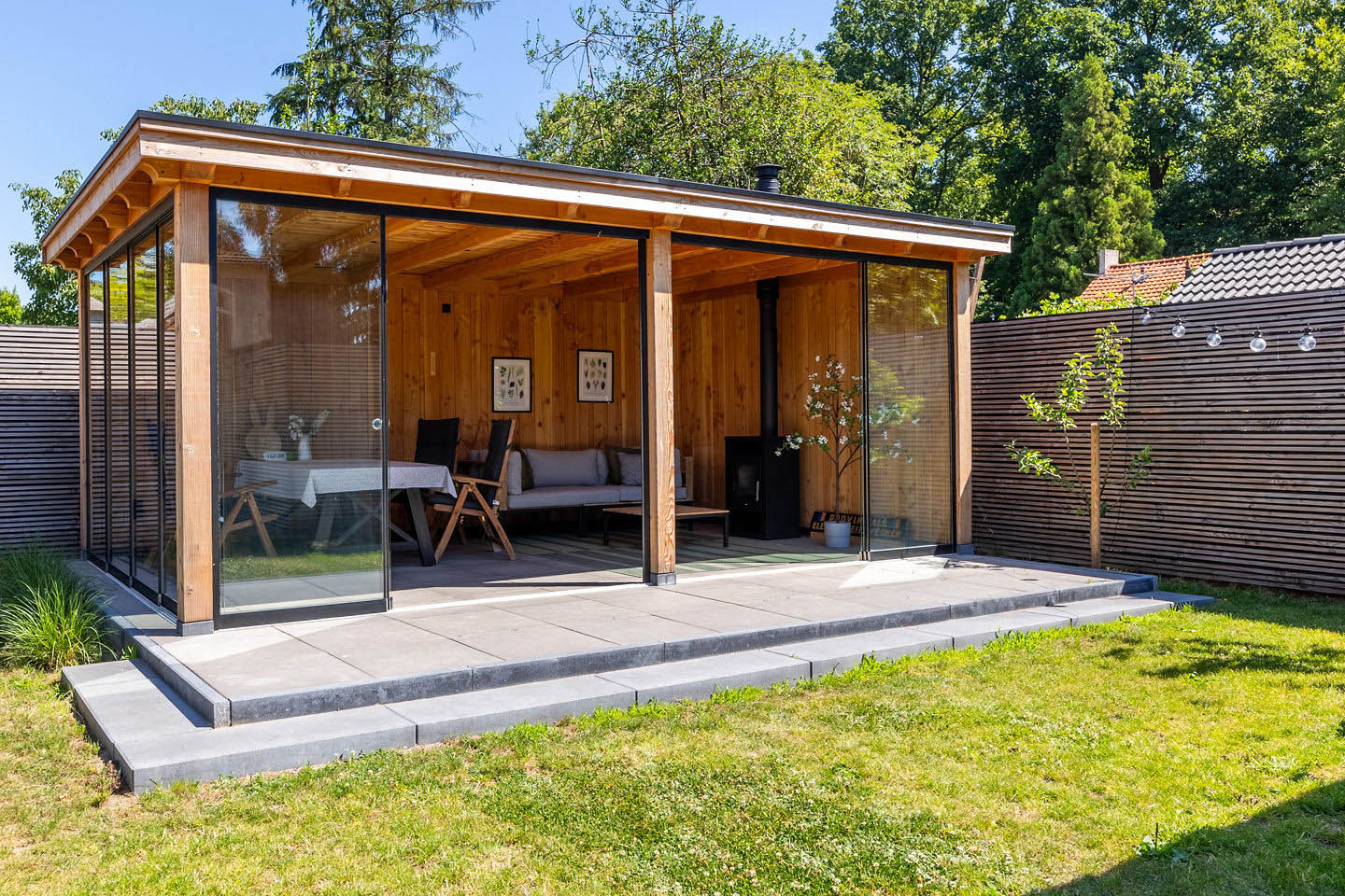overkapping-siena-met-douglas-constructie-glazen-schuifwanden-houten-achterwand-en-zitgedeelte-in-de-tuin