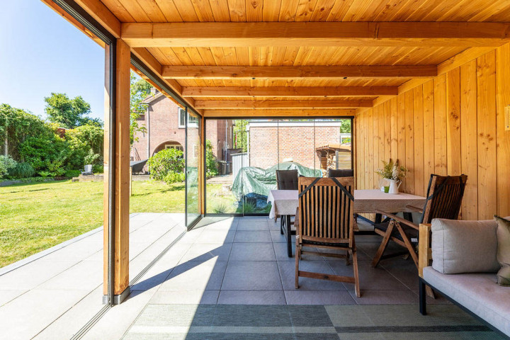 binnenaanzicht-van-overkapping-siena-met-douglas-constructie-glazen-schuifwand-zitgedeelte-en-uitzicht-op-de-tuin