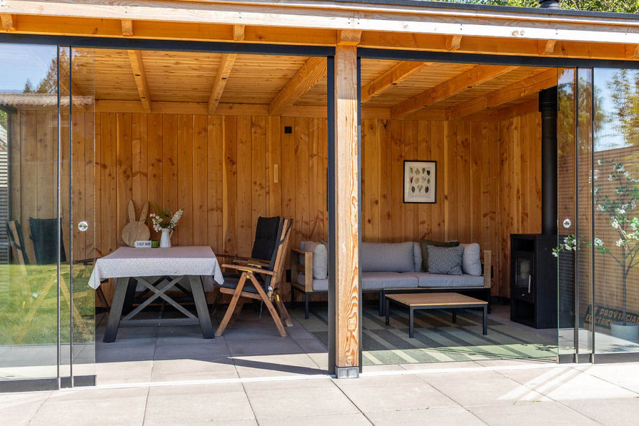 vooraanzicht-van-overkapping-siena-met-glazen-schuifwanden-douglas-constructie-en-zitgedeelte-op-het-terras