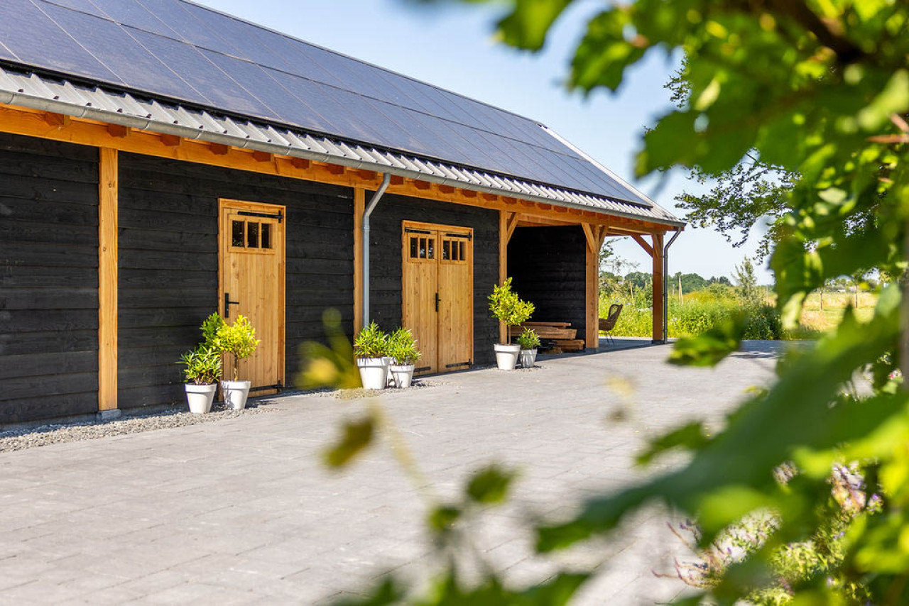 ijaanzicht-van-zadeldak-xxl-met-douglas-constructie-wanden-van-douglas-potdekselplanken-douglas-opgeklampte-deuren-en-douglas-ramen-met-open-overkapping-in-de-tuin