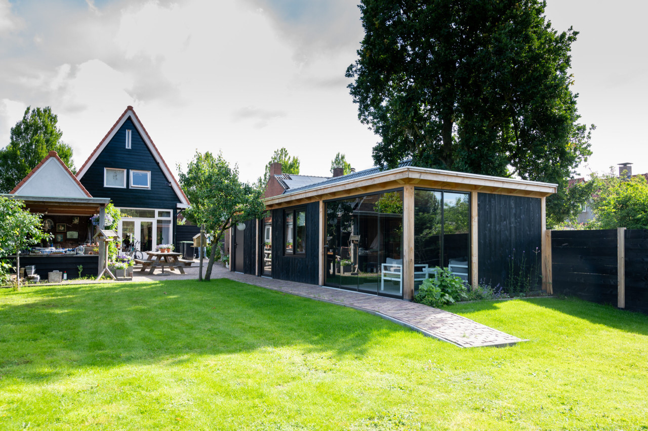 overzichtsfoto-van-overkapping-florence-met-douglas-constructie-wanden-van-douglas-sponningsplanken-glazen-schuifwanden-steellook-deur-steellook-ramen-en-hardhouten-plaatdeur-in-de-tuin