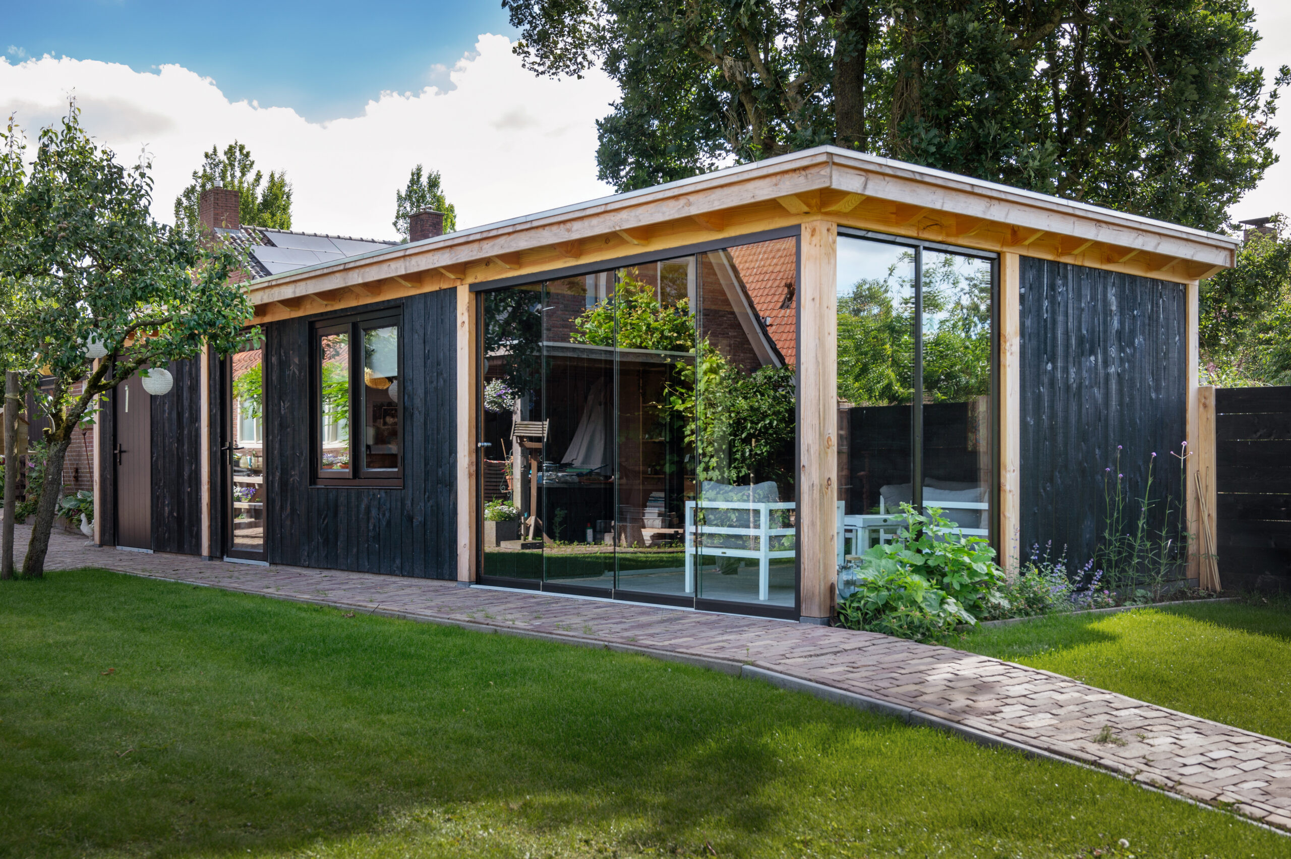 overkapping-florence-met-douglas-constructie-wanden-van-douglas-sponningsplanken-glazen-schuifwanden-steellook-deur-hardhouten-plaatdeur-en-steellook-raam-in-de-tuin