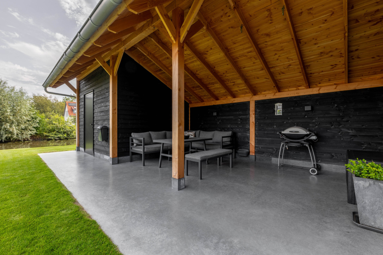 detail-van-open-gedeelte-van-kapschuur-de-heerd-met-douglas-constructie-zithoek-en-barbecue-onder-het-dak