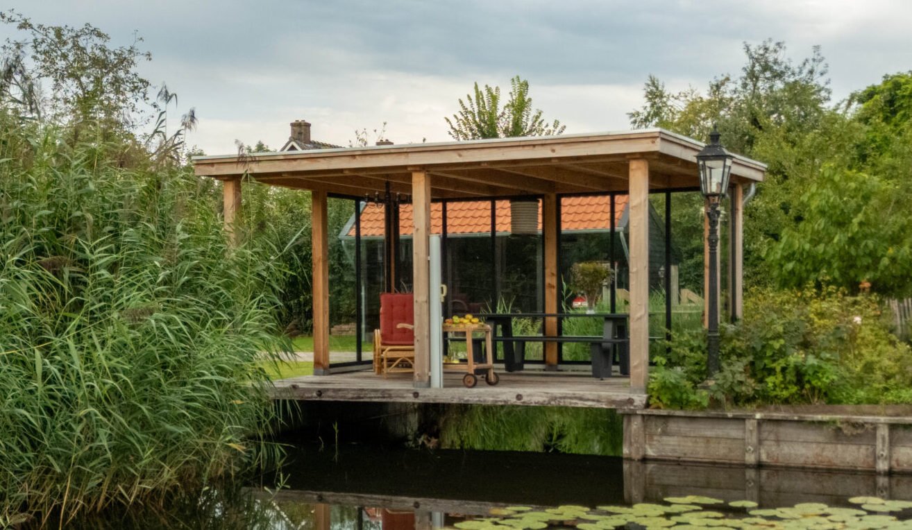 overkapping-siena-als-lichte-en-open-tuinkamer-met-glazen-wanden-op-vlonder-aan-het-water