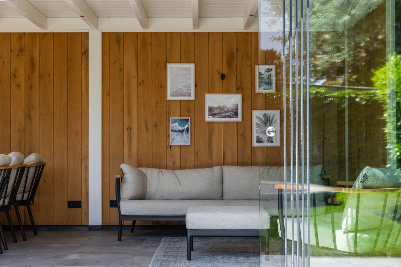 detail-van-zithoek-in-overkapping-verona-met-wanden-van-eiken-sponningsplanken-en-glazen-schuifwand-in-de-tuinkamer