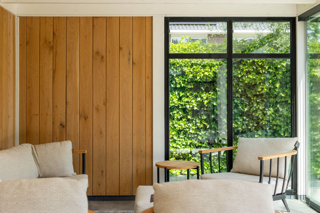 detail-van-zithoek-in-overkapping-verona-met-wanden-van-eiken-sponningsplanken-en-steellook-raammodule-in-de-tuinkamer