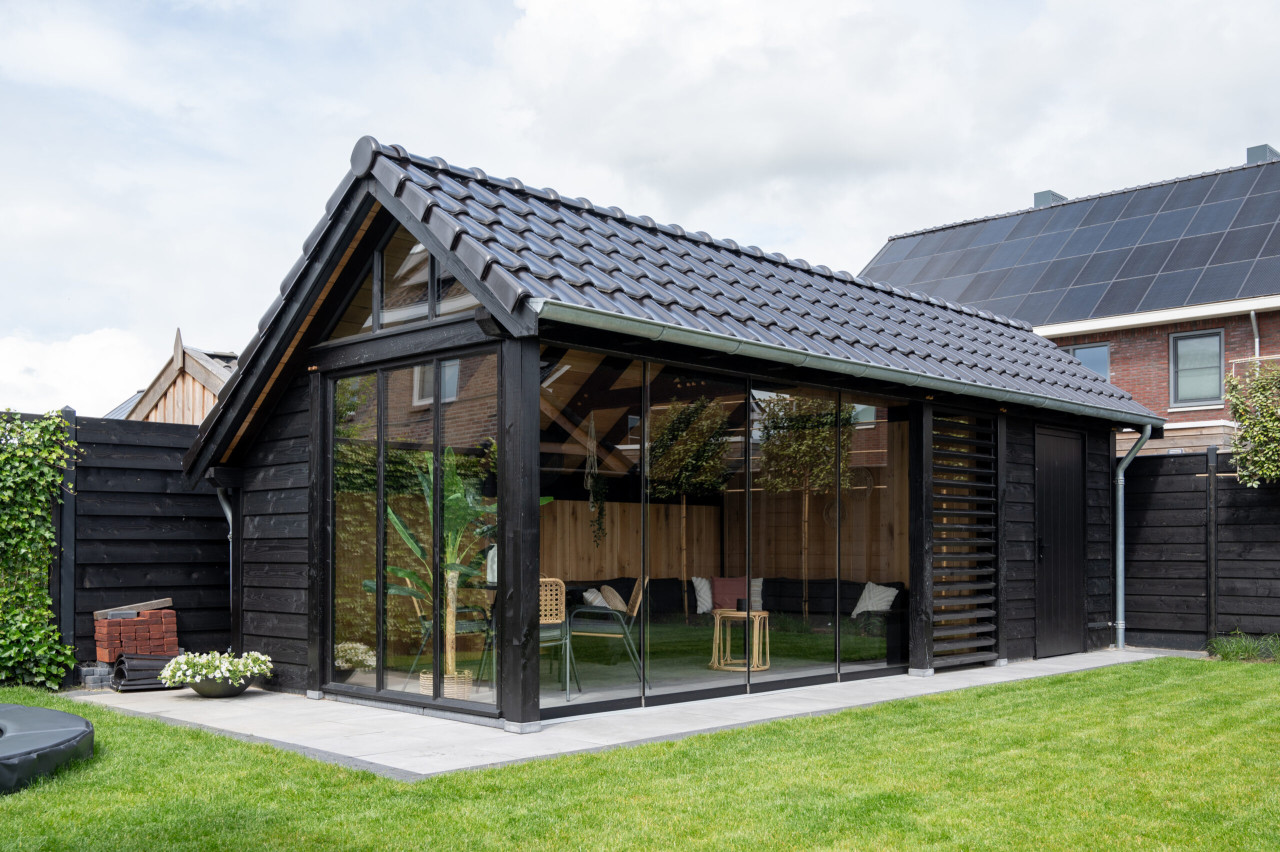 kapschuur-de-hoeve-xl-met-douglas-constructie-wanden-van-douglas-potdekselplanken-zwart-steellook-raam-en-glazen-schuifwand-in-de-tuin