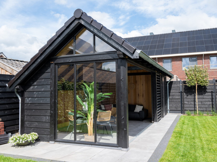 ooraanzicht-van-kapschuur-de-hoeve-xl-met-douglas-constructie-wanden-van-douglas-potdekselplanken-zwart-steellook-topgevel-en-glazen-schuifwand-in-de-tuin