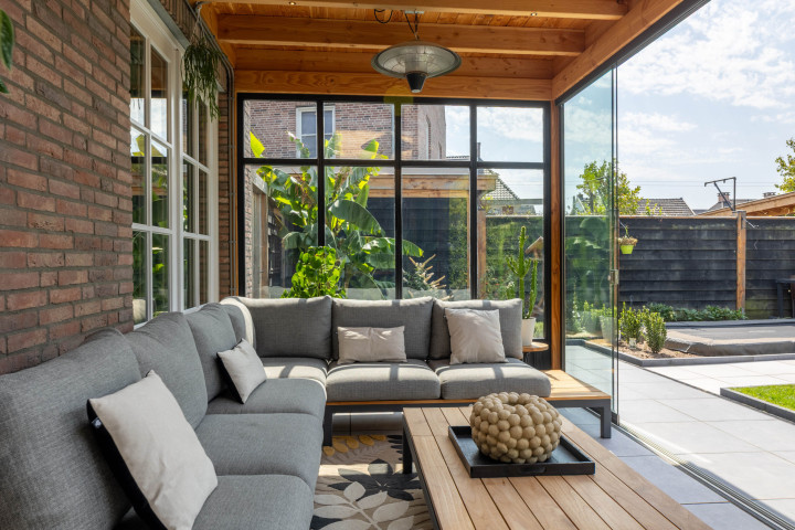 binnenaanzicht-van-veranda-lucca-met-douglas-constructie-zithoek-glazen-schuifwanden-en-steellook-raammodule-in-de-tuinkamer