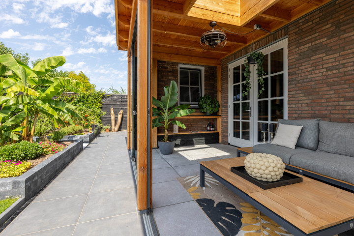 detail-van-veranda-lucca-met-douglas-constructie-zithoek-glazen-schuifwanden-en-lichtstraat-lessenaar-aan-de-woning-in-de-tuin