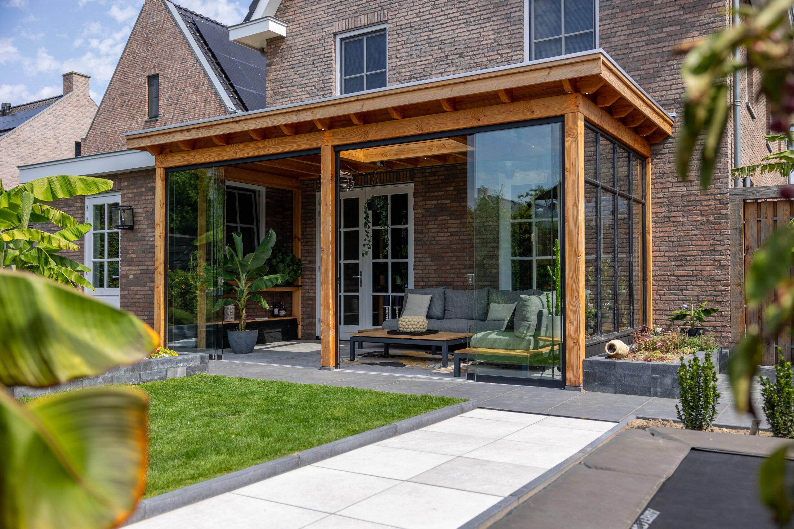 veranda-lucca-met-douglas-constructie-steellook-raammodule-glazen-schuifwanden-lichtstraat-lessenaar-en-inbouwspots-in-de-tuin