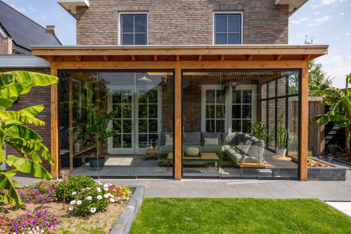 vooraanzicht-van-veranda-lucca-met-douglas-constructie-glazen-schuifwanden-steellook-raammodule-en-lichtstraat-lessenaar-aan-de-woning-in-de-tuin