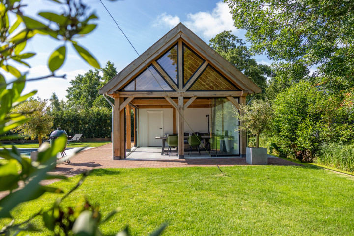 vooraanzicht-van-zadeldak-eiken-met-eiken-constructie-glazen-schuifwand-steellook-topgevel-en-open-zitgedeelte-in-de-tuin