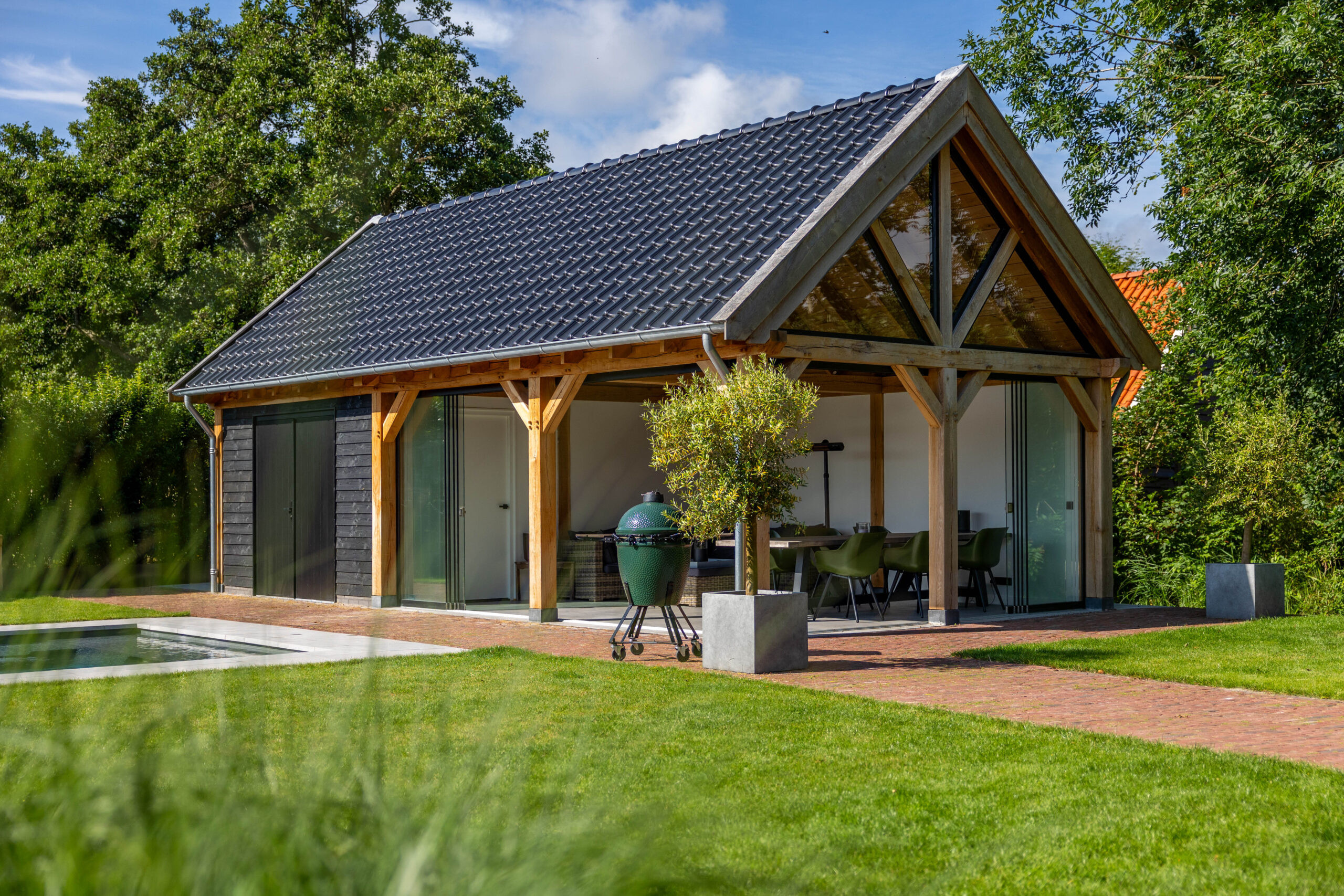 zadeldak-eiken-met-eiken-constructie-wanden-van-douglas-potdekselplanken-zwart-glazen-schuifwand-hardhouten-plaatdeur-dubbel-steellook-uitzetraam-en-steellook-topgevel-inbouwspots-rvs-keramische-dakpannen-mat-zwart-verglansd-en-zinken-dakgoot-in-de-tuin