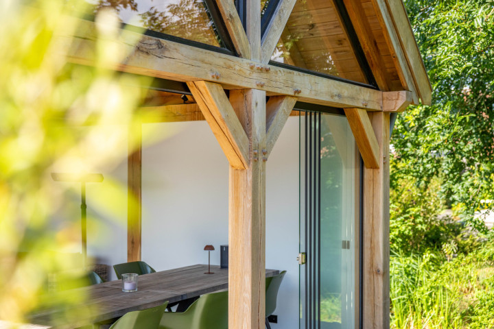 detail-van-eiken-constructie-met-schoren-en-glazen-schuifwand-bij-zadeldak-eiken-in-de-tuin