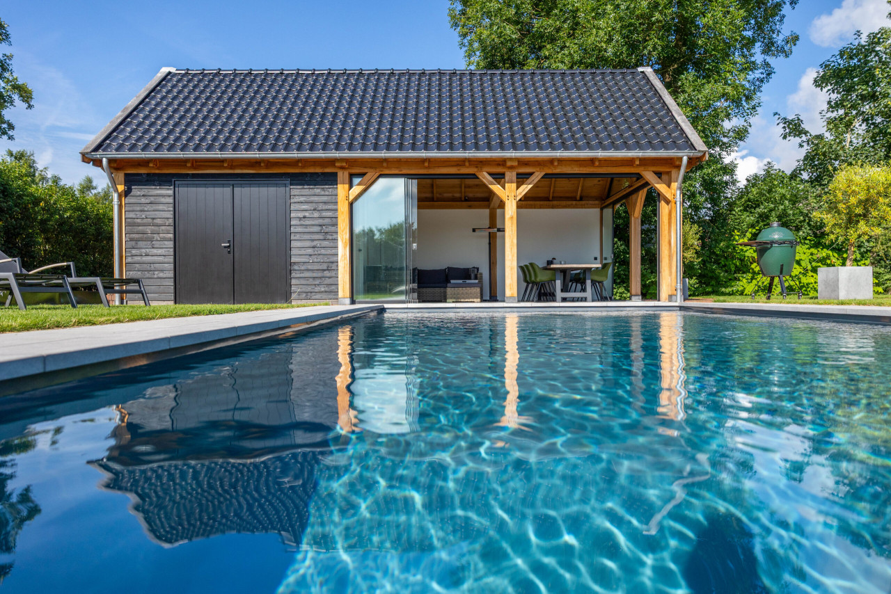 zijaanzicht-van-zadeldak-eiken-met-eiken-constructie-wanden-van-douglas-potdekselplanken-zwart-glazen-schuifwand-hardhouten-plaatdeur-dubbel-en-steellook-topgevel-bij-zwembad-in-de-tuin