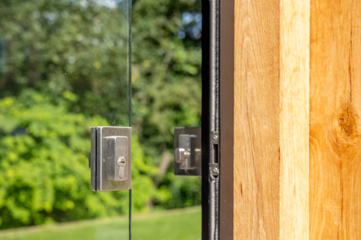 detail-van-glazen-schuifwand-met-slot-en-eiken-constructie-bij-zadeldak-eiken-in-de-tuin