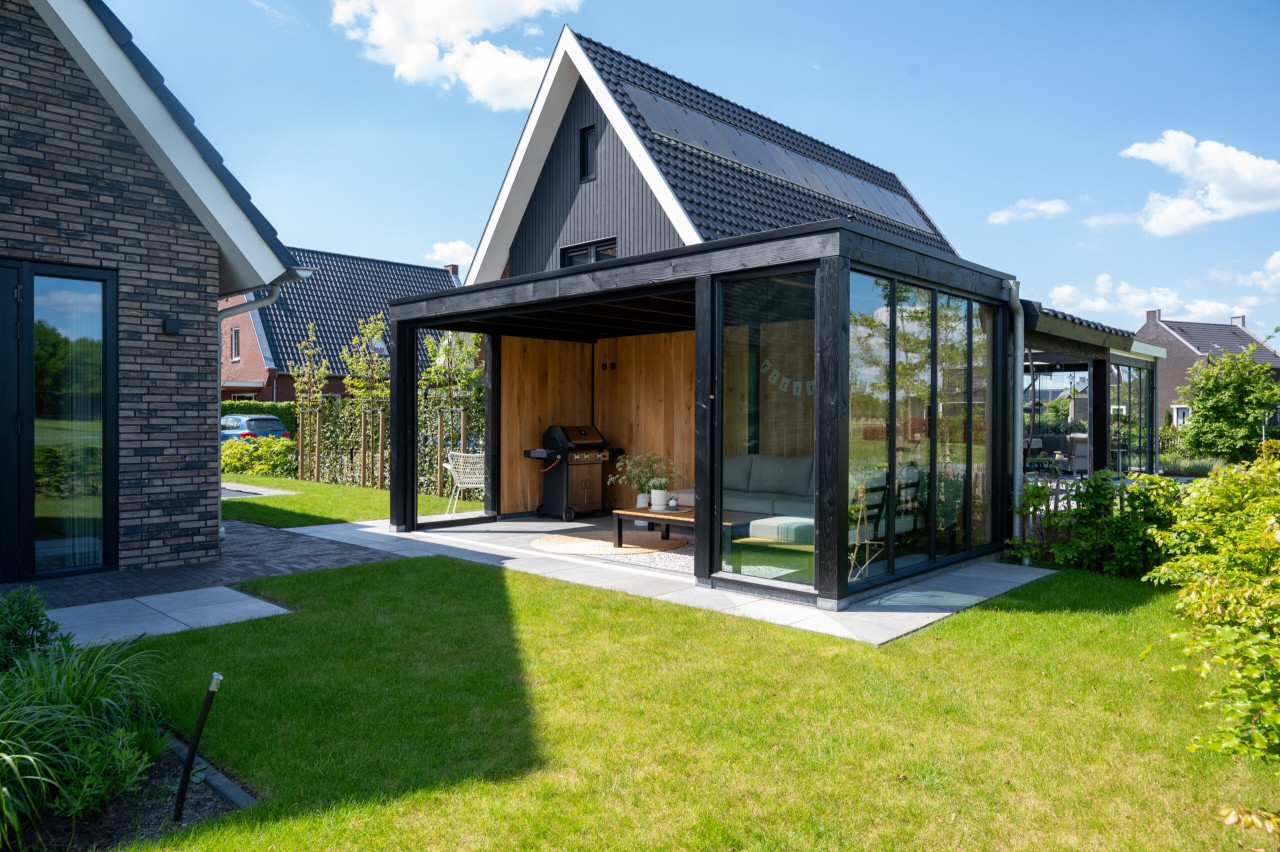 overkapping-palermo-met-zwarte-douglas-constructie-eiken-sponningsplanken-steellook-raam-en-glazen-schuifwanden-in-de-tuin